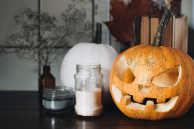 Ahşap masada Cadılar Bayramı 'nda balkabağı üzerinde ürkütücü Jack-o-fener suratı. Arka plan, kopyalama alanı, kapatın. Cadılar Bayramı parti dekorasyonu arifesi. Şaka mı şeker mi konsepti.