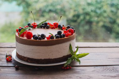 Ahşap bir masada dutlu kremalı pasta. Frenk üzümü ve kirazlı çikolatalı pasta. Doğum günü, düğün ve diğer tatiller için çilekli pasta..