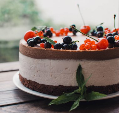 Ahşap bir masada dutlu kremalı pasta. Frenk üzümü ve kirazlı çikolatalı pasta. Doğum günü, düğün ve diğer tatiller için çilekli pasta..