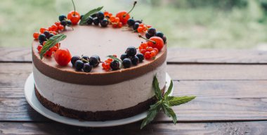 Ahşap bir masada dutlu kremalı pasta. Frenk üzümü ve kirazlı çikolatalı pasta. Doğum günü, düğün ve diğer tatiller için çilekli pasta..