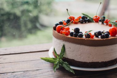 Ahşap bir masada dutlu kremalı pasta. Frenk üzümü ve kirazlı çikolatalı pasta. Doğum günü, düğün ve diğer tatiller için çilekli pasta..