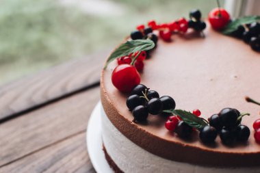 Ahşap bir masada dutlu kremalı pasta. Frenk üzümü ve kirazlı çikolatalı pasta. Doğum günü, düğün ve diğer tatiller için çilekli pasta..