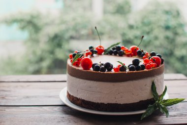 Ahşap bir masada dutlu kremalı pasta. Frenk üzümü ve kirazlı çikolatalı pasta. Doğum günü, düğün ve diğer tatiller için çilekli pasta..