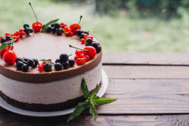 Ahşap bir masada dutlu kremalı pasta. Frenk üzümü ve kirazlı çikolatalı pasta. Doğum günü, düğün ve diğer tatiller için çilekli pasta..