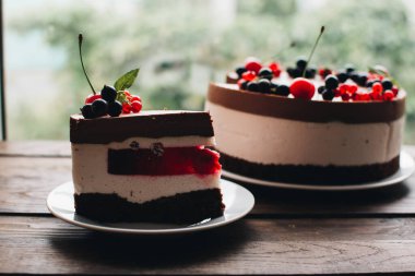 Ahşap bir masada dutlu kremalı pasta. Frenk üzümü ve kirazlı çikolatalı pasta. Doğum günü, düğün ve diğer tatiller için çilekli pasta..