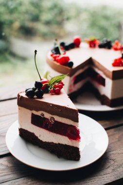 Ahşap bir masada dutlu kremalı pasta. Frenk üzümü ve kirazlı çikolatalı pasta. Doğum günü, düğün ve diğer tatiller için çilekli pasta..