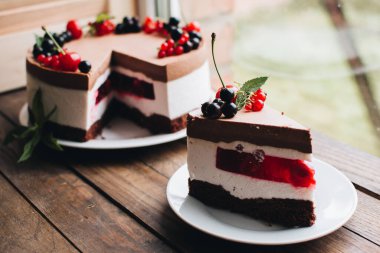 Ahşap bir masada dutlu kremalı pasta. Frenk üzümü ve kirazlı çikolatalı pasta. Doğum günü, düğün ve diğer tatiller için çilekli pasta..