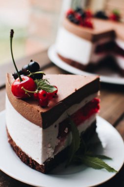 Ahşap bir masada dutlu kremalı pasta. Frenk üzümü ve kirazlı çikolatalı pasta. Doğum günü, düğün ve diğer tatiller için çilekli pasta..