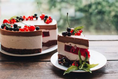 Ahşap bir masada dutlu kremalı pasta. Frenk üzümü ve kirazlı çikolatalı pasta. Doğum günü, düğün ve diğer tatiller için çilekli pasta..