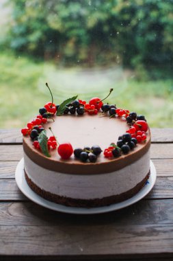 Ahşap bir masada dutlu kremalı pasta. Frenk üzümü ve kirazlı çikolatalı pasta. Doğum günü, düğün ve diğer tatiller için çilekli pasta..
