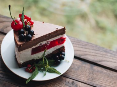 Ahşap bir masada dutlu kremalı pasta. Frenk üzümü ve kirazlı çikolatalı pasta. Doğum günü, düğün ve diğer tatiller için çilekli pasta..