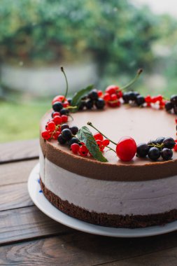 Ahşap bir masada dutlu kremalı pasta. Frenk üzümü ve kirazlı çikolatalı pasta. Doğum günü, düğün ve diğer tatiller için çilekli pasta..