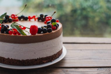 Ahşap bir masada dutlu kremalı pasta. Frenk üzümü ve kirazlı çikolatalı pasta. Doğum günü, düğün ve diğer tatiller için çilekli pasta..