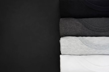 Üst görünüm siyah, gri ve beyaz (monokrom) t-shirt rol yığını