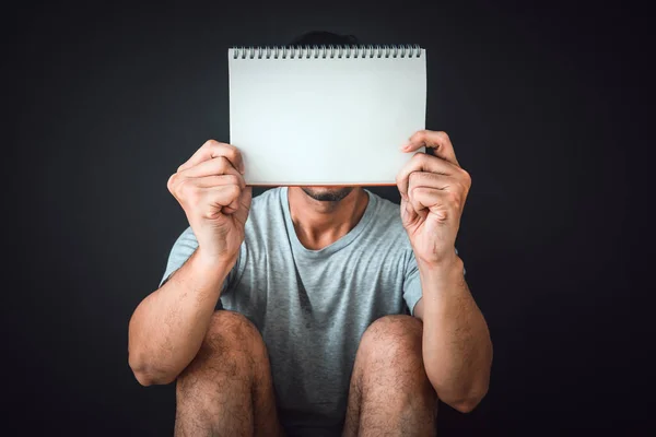 Man Sitting Floor Black Color Background Holding Blank Notebook Copy Obrazy Stockowe bez tantiem