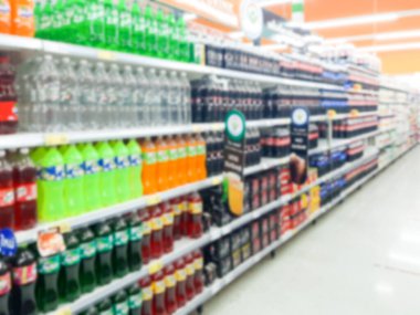 Modern süpermarkette soyut, bulanık meşrubat, maden suyu ve içecek ürünleri raflarda..