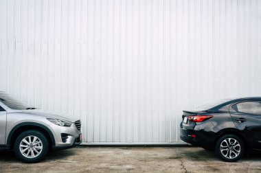 Phuket, Tayland - 4 Ekim 2016: Beton zemine park etmiş siyah ve bronz renkli arabalar ve garajda metal levha duvar arkası var.