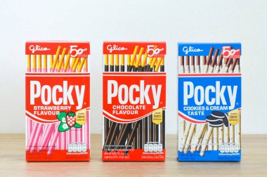 Phuket, Tayland - 12 Kasım 2020: Beyaz arka planlı ahşap masa üzerinde Glico marka Çopur bisküvi çubukları çilek, çikolata, kurabiye ve krema aroması (sınırlı retro koleksiyonu) paketleme kutusu