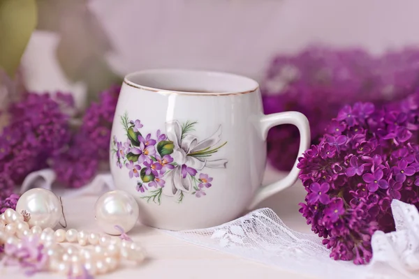 A cup of tea or coffee with a pattern in lilac bouquet of lilacs — Stock Photo, Image