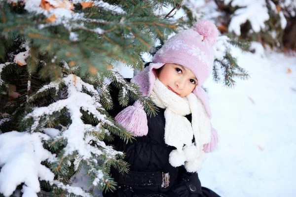Wesoły piękna dziewczyna w kapeluszu fioletowy zimą w śniegu pod choinkę — Zdjęcie stockowe