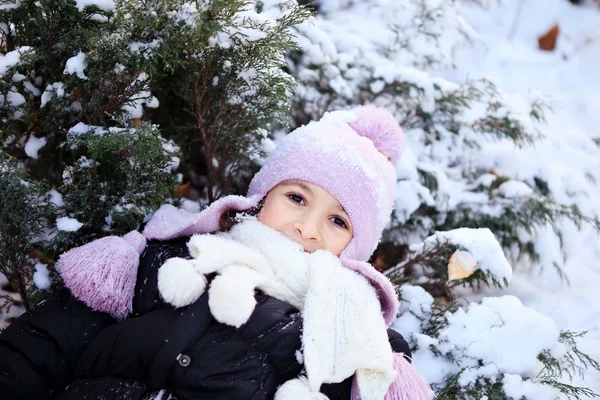 Veselá krásná dívka ve fialové zimní čepice sněhu pod vánoční stromeček — Stock fotografie