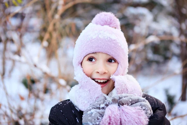 Cheerful beautiful girl in purple winter hat in the snow under the Christmas tree — Stock Photo, Image