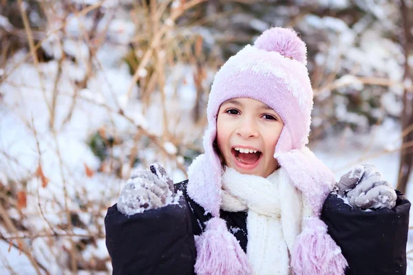 Cheerful beautiful girl in purple winter hat in the snow under the Christmas tree — Stock Photo, Image
