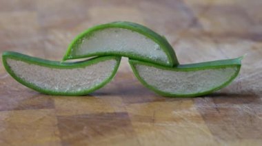 Dilimlenmiş aloe vera tahtanın üzerinde yatıyor.