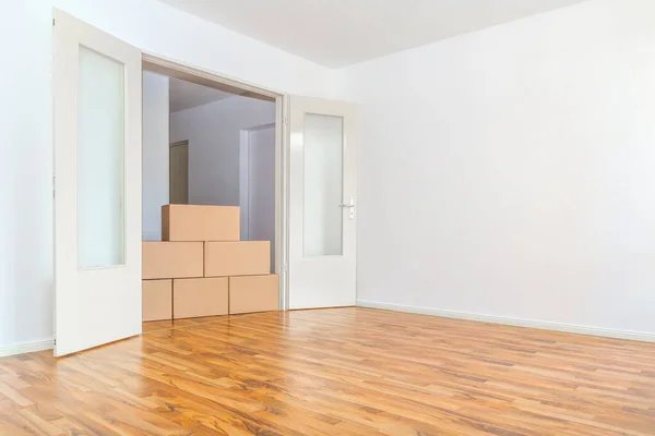 在一个空荡荡的公寓里靠着一面白墙移动箱子 — 图库照片