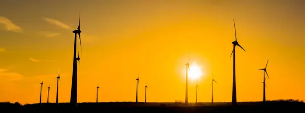 日落时的许多风力涡轮机的全景 — 图库照片