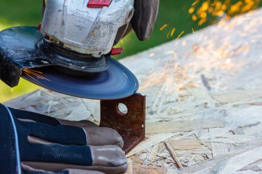 Metal parçalar elektrikli öğütücüyle işleniyor, kıvılcımlar uçuşuyor.