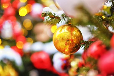 Noel ağacı süslemeleri. Ağaçtaki altın top. Yılbaşı ışıkları ve bokeh 'in arka planında. Noel arkaplanı