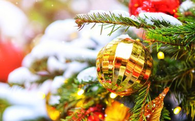 Bulanık bir zemin üzerinde ağaçta altın bir yeni yıl topu.