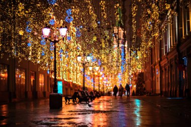 Nikolskaya Caddesi 'ndeki Moskova' nın merkezinde gece karanlığında bulanık ışıklar. Kaldırımdaki ışığın yansıması.