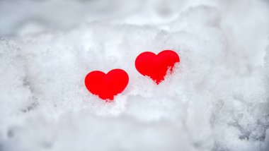 Beyaz karda iki kırmızı kalp. Sevgililer Günü konsepti. Aşkın sembolü