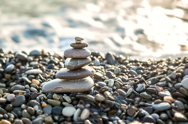 Pyramid stones are balancing on the BEACH SHORE. Object is in focus, background is blurred