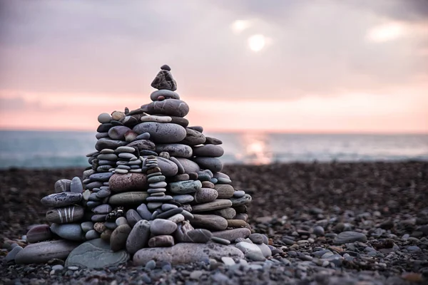 The pyramid stones balance the beach against the backdrop of the sea sunset