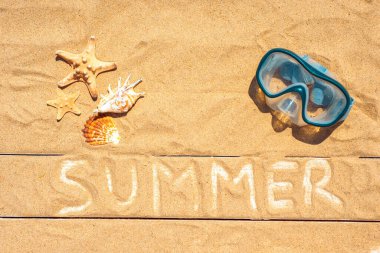 Yaz tabelası, deniz kabukları, kumlu arka planda yüzme maskesi. Flatlay, üst manzara. Yaz arkaplanı.