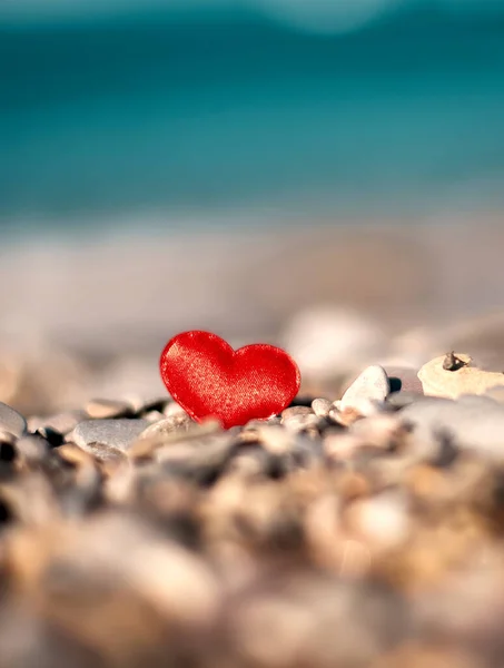 海のせせらぎの中の石に赤いハート 愛のシンボル — ストック写真