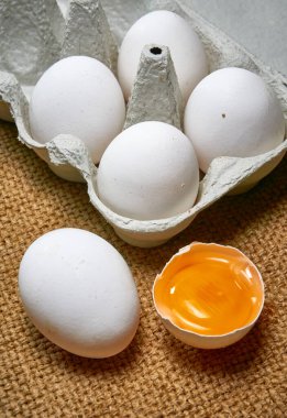 Çuval bezinde karton bir kutuda taze çiğ tavuk yumurtası.