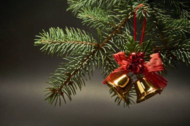 Siyah arka planda çanları olan bir Noel süsü.