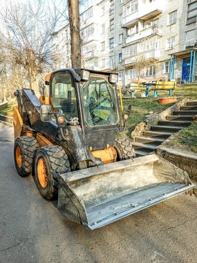 Şehrin sokaklarında yükleme ve boşaltma için küçük ön uç yükleyici.