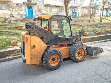 Şehrin sokaklarında yükleme ve boşaltma için küçük ön uç yükleyici.