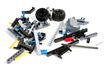 Yapıcının plastik parçaları, hareket edebilen modelleri beyaz arka planda birleştirmek için elementleri ve tekerlekleri bağlayan, yüzen odaklı