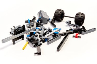 Yapıcının plastik parçaları, hareket edebilen modelleri beyaz arka planda birleştirmek için elementleri ve tekerlekleri bağlayan, yüzen odaklı