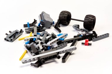 Yapıcının plastik parçaları, hareket edebilen modelleri beyaz arka planda birleştirmek için elementleri ve tekerlekleri bağlayan, yüzen odaklı