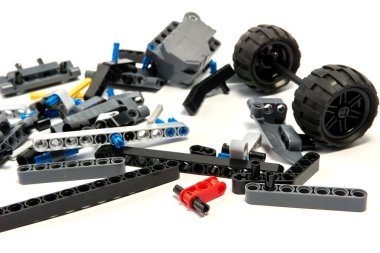 Yapıcının plastik parçaları, hareket edebilen modelleri beyaz arka planda birleştirmek için elementleri ve tekerlekleri bağlayan, yüzen odaklı