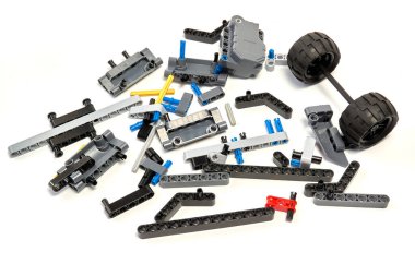 Yapıcının plastik parçaları, hareket edebilen modelleri beyaz arka planda birleştirmek için elementleri ve tekerlekleri bağlayan, yüzen odaklı