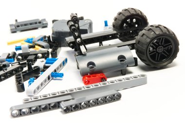 Yapıcının plastik parçaları, hareket edebilen modelleri beyaz arka planda birleştirmek için elementleri ve tekerlekleri bağlayan, yüzen odaklı