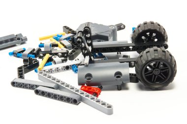 Yapıcının plastik parçaları, hareket edebilen modelleri beyaz arka planda birleştirmek için elementleri ve tekerlekleri bağlayan, yüzen odaklı